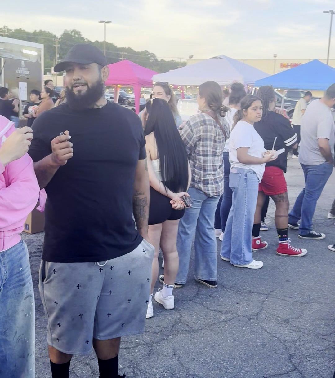 A crowd lined up at colorful vendor tents