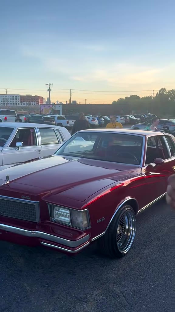 Candy red lowrider on wire wheels at sunset